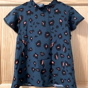 Cute top with ruffle neck, flouncy short sleeve. Can be worn loose or tucked in